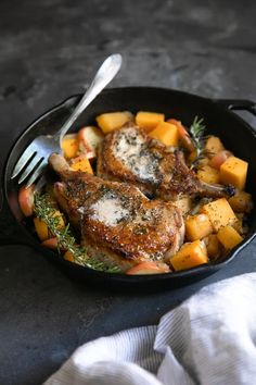 some meat and potatoes in a pan with a fork