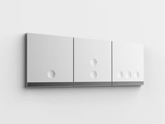 a white wall mounted cabinet with four different knobs on the front and two smaller buttons on the back