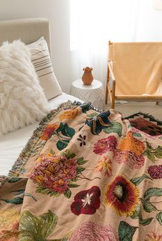 a bed covered in a blanket with flowers on it