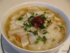 a white bowl filled with noodles and vegetables