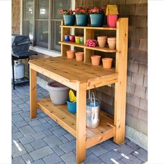 potted plants are sitting on top of a wooden shelf next to a bbq