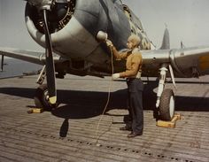 a man standing next to an airplane on top of a tarmac