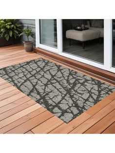 a door mat on the outside of a house with wood flooring and sliding glass doors