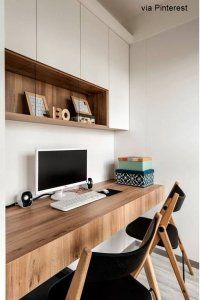 a wooden desk with a computer monitor and keyboard sitting on top of it next to a chair