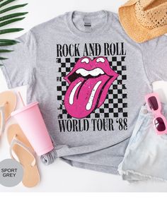 Rock on with our Kiss of Vintage Rock Tee: Tour '88! This edgy t-shirt features a bold pink kiss mouth design on the front, adding a touch of rock and roll flair to your wardrobe. With its vintage vibe and cool "Tour '88" print, this tee is perfect for music lovers and trendsetters alike. Made from high-quality cotton for maximum comfort and durability, it's the ultimate statement piece for any rock-inspired outfit. Get ready to turn heads and rock out in style with this must-have tee! *Unisex Sizing* Vintage Rock Tees, Mouth Design, Rock Tees, Vintage Rock, Rock On, Vintage Vibe, Vintage Vibes, Military Green, Music Lovers