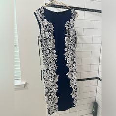 a blue dress hanging on a white tiled wall