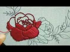 someone is stitching a rose on a piece of fabric