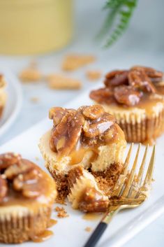 two cupcakes with nuts on top and a fork in the middle, ready to be eaten