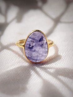 This bold gold statement ring features organic shaped Tanzanite that brings a sense of calm and divine energy. Tanzanite is one of the most rare and powerful stones. Connecting mind, heart, and soul to create one being. Wear it solo or stack it with our other favorite rings. ✦ DETAILS ✦ ✧ Name: Kila (KEE laa) - high, strong. ✧ Available in whole sizes 5-9.  ✧ Genuine Tanzanite Stone. ✧ 18kt Gold Vermeil. ✧ All Ke Aloha Jewelry pieces come packaged thoughtfully, beautifully, and ready for gift gi Luxury Amethyst Tanzanite Ring In Fine Jewelry Style, Luxury Amethyst Tanzanite Ring Fine Jewelry, Tanzanite And Tourmaline Ring, Luxury Tanzanite Amethyst Ring As Gift, Luxury Tanzanite Ring With Bezel Setting, Rings With Tanzanite, Luxury Tanzanite Amethyst Ring Gift, Ethereal Gold Rings With Gemstones, Gold Amethyst Ring With Large Stone As Gift