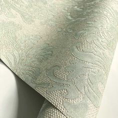 a close up view of a green and white wallpaper with an intricate design on it