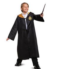 a young boy dressed in a harry potter costume holding a wand and pointing at something