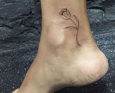 a small flower tattoo on the side of a person's foot, which reads jespaisatottoo