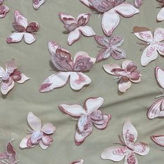 pink and white butterflies are on a light green fabric with silver foiled edges,