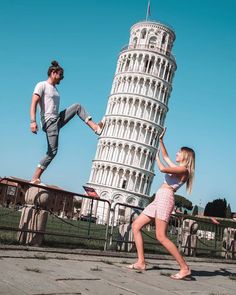 two people are dancing in front of the leaning tower with their legs spread out and one person is jumping up