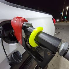 an electric car being charged at a gas station in the evening time with no fuel