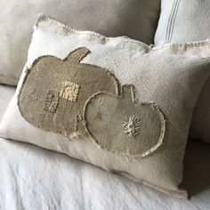 a pillow with an apple on it sitting on a bed