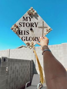 someone holding up a graduation cap that says, my story has glow