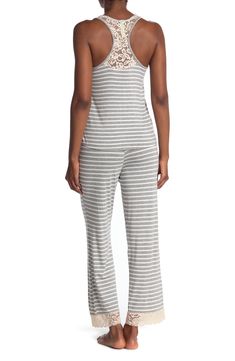 Lounge in ultimate comfort in this super soft scoop neck tank and pajama bottoms set. 2-piece set Top: 24" length; Pants: 13" rise, 29" inseam (size S) Top: scoop neck, sleeveless, racerback, knit construction, lace trim Bottoms: elasticized drawstring waist, pull-on style, knit construction, lace trim 95% rayon, 5% spandex Machine wash Imported Model’s stats for sizing: 5’11” height, 32” bust, 24” waist, 34” hips. Model is wearing size S. Casual Stretch Camisole For Loungewear, Casual Camisole Sleepwear, Casual Camisole Sleepwear For Loungewear, Casual Cotton Camisole For Pajama Party, Spring Camisole For Pajama Party, Stretch Camisole For Loungewear, Casual Camisole Sleepwear For Lounging, Fitted Cotton V-neck Sleepwear, Gray Moisture-wicking Bottoms For Loungewear