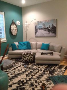 a living room filled with furniture and a clock on the wall above it's windows