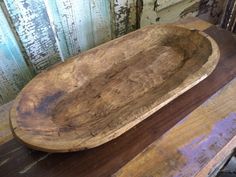 an old wooden bowl sitting on top of a table