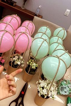 a table topped with vases filled with pink and green balloons