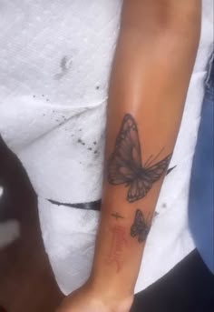 a woman's arm with a butterfly tattoo on the left side of her arm