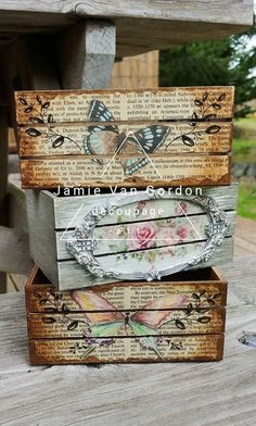 three wooden boxes sitting on top of a wooden table covered in butterflies and flowers,