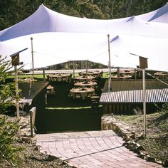 tables and chairs are set up under a white tent