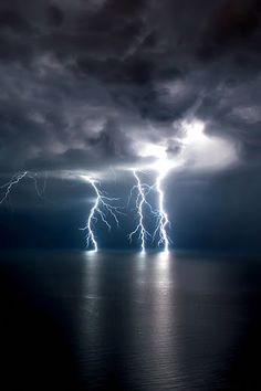 two lightning strikes over the ocean on a cloudy day