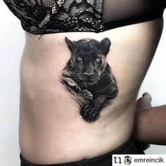 a woman's stomach with a black cat tattoo on it