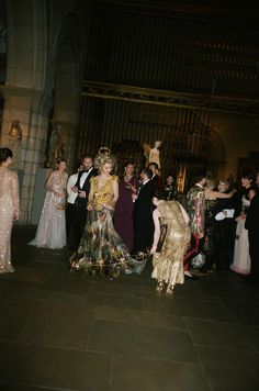 a group of people standing around each other at a formal event in an old building