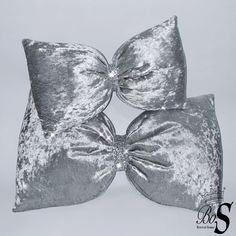 three silver velvet bows on top of each other in the shape of a bow, against a white background