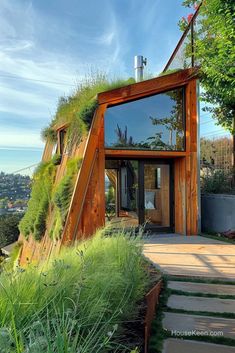 a house with grass on the roof and stairs leading up to it's entrance