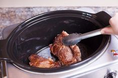 someone is stirring some food in the slow cooker