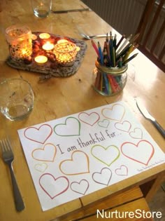 a wooden table topped with lots of different types of candles and paper on top of it