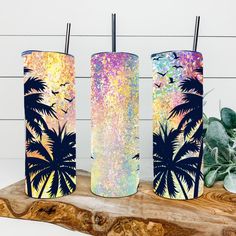 three tumbles with palm trees painted on them