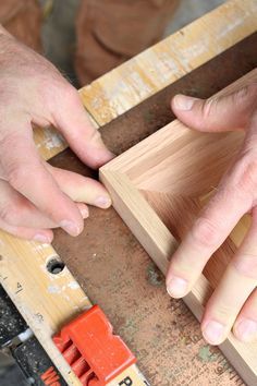 two hands are working on some wood