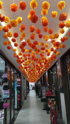 the ceiling is decorated with orange and yellow paper flowers