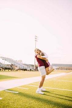 two people hugging on a tennis court with the sky in the backgrouds