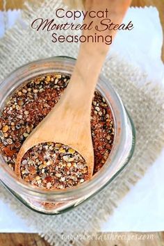 a wooden spoon in a glass jar filled with seasoning on top of a table