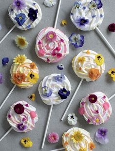 several lollipops with flowers on them sitting next to some candy canes