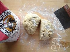 two pieces of bread sitting on top of a wooden cutting board next to a bag