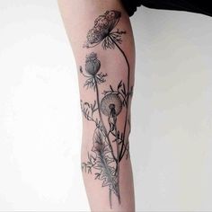 a woman's leg with flowers and leaves on it