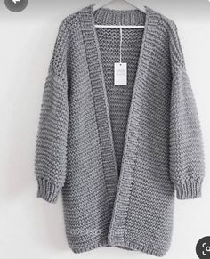 a gray cardigan sweater hanging on a hanger with the tag attached to it