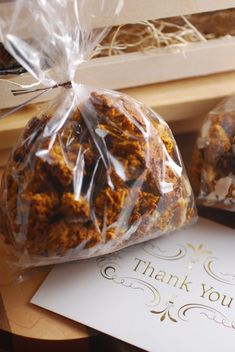 two bags filled with food sitting on top of a table next to a thank card