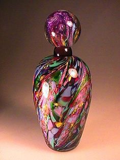 a colorful glass vase sitting on top of a table