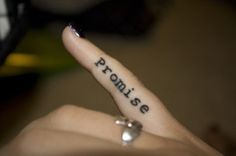 someone has written on their finger with the word pronise in cursive writing