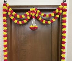 a door decorated with red, yellow and white pom - pom garlands