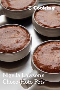 four brownie pans sitting on top of a stove with chocolate cake in them