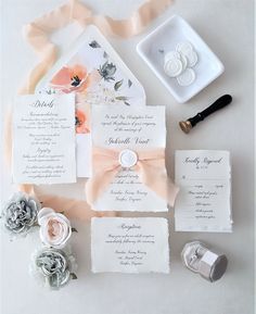 the wedding stationery is laid out on top of each other with flowers and ribbons